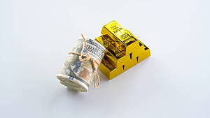 Stack of gold bars next to dollar